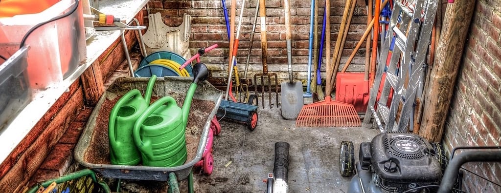 Shed with spring garden cleanup and pruning tools.