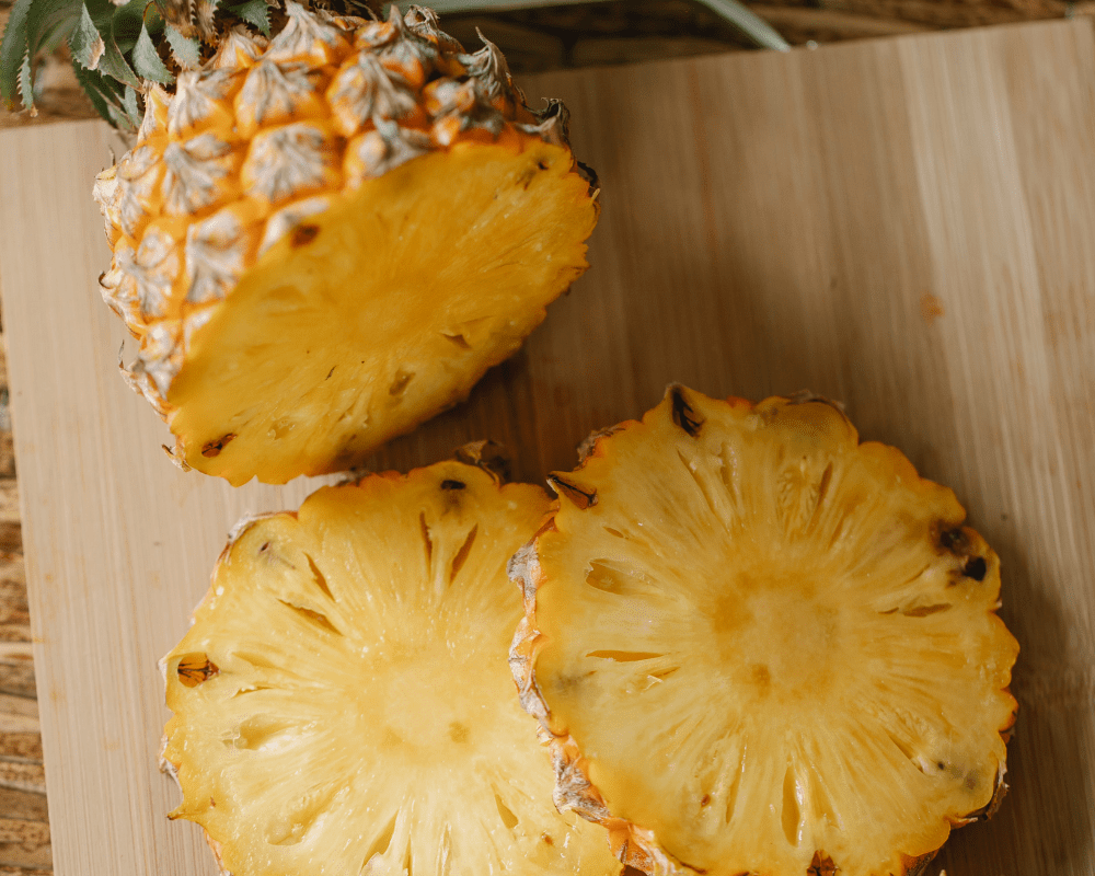 Pineapples cut on a cutting board.